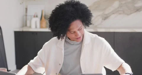 African American man checking tablet, annotating papers with pen, typing on 库存影片 337239144