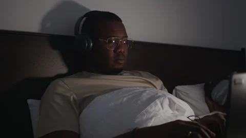 African American Man Coding on Laptop while His Wife Sleeping Stock Footage 328516158