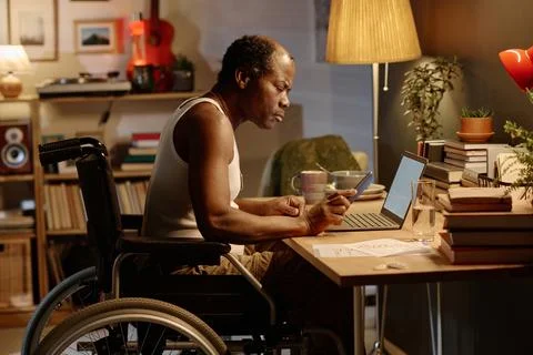 African American Man with Disability Using Wireless Technologies at Home 스톡 사진
