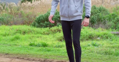 African American man doing warmup drill on dirt path walking to camera in hoodie Stock Footage 341027696