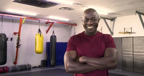 African american man facing camera at dojo, relaxing then smiling and laughing Stock Footage 341931629
