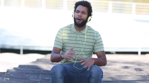African american man with headphones listening to music and singing Stock Footage 59555486