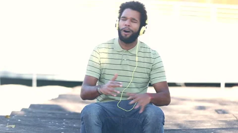 African american man with headphones listening to music and singing Stock Footage 59555487