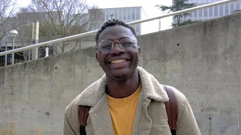 African American man looking at camera smiling.Student wearing glasses.4k video. Stock Footage 221249638