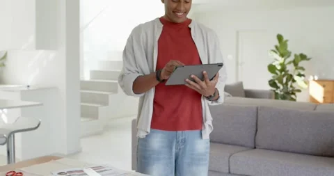 African American man noticing patterns on wood table stepping and tapping tablet Stock Footage 344964645