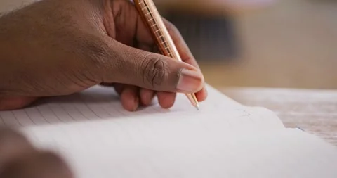 African American man pausing after jotting notebook-notes with pen typing to Stock Footage 339592088