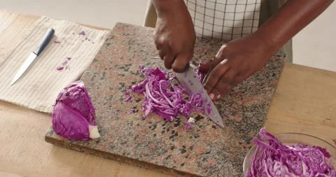 African American man placing half cabbage for slaw, steadying, chopping with Stock Footage 342023344