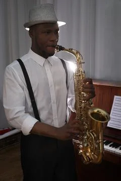 African-American man playing saxophone indoors. Talented musician Stock Photos