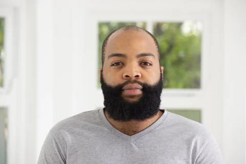 African American man posing in front of white window frames, facing camera, Stock Photos