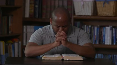 African American Man Prays While Beating Chest In Home Library Stock Footage 111297286