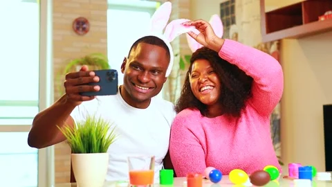 African american man preparing for Easter in apartment calling to family by Stock Footage 163086120