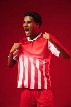 African American man pulling red-and-white striped jersey away and shouting in Stock Photos