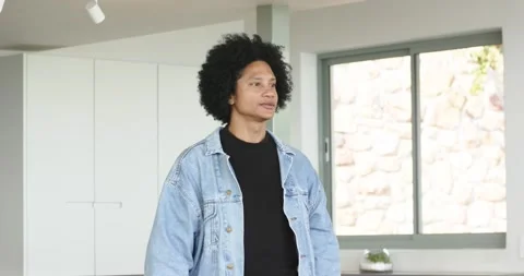 African American man pushing off kitchen island turning to window nodding Stock Footage 334923817