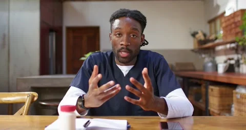 African American man in scrubs explaining medication, checking notes and Stock Footage 341944964