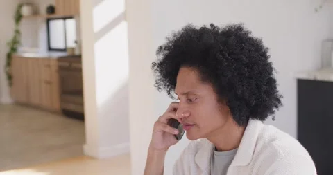 African American man taking call, referencing laptop and tablet, working at Stock Footage 337239140
