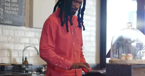 African American man tapping register keypad at cafe, celebrating sale Stock Footage 341932005