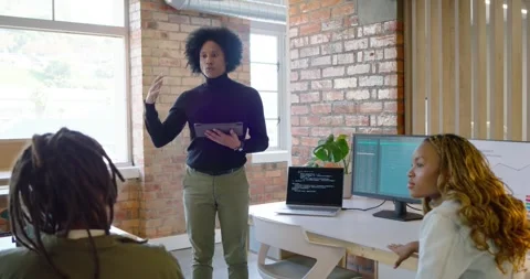 African American man tapping tablet leading meeting in office reviewing laptop Stock Footage 337944527
