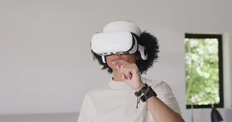 African American man tapping VR headset then gesturing to manipulate VR objects Stock Footage 337288074