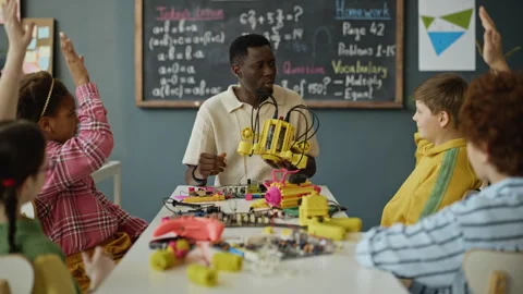 African American Man Teacher Explaining Robotics to Multiethnic Children Stock Footage 340552740