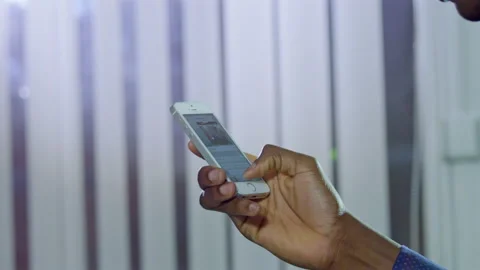 African American man types message on modern smartphone Stock Footage 228780307