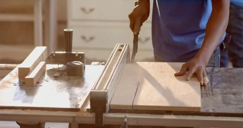 African American man using chisel on wooden board on shop workbench, with clamp Stock Footage 311026710