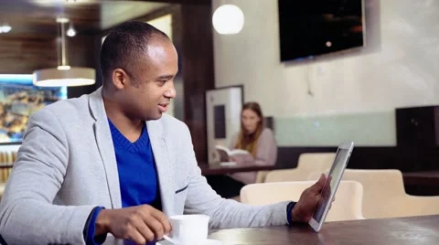 African American man using his tablet in a cafe Stock Footage 56588101