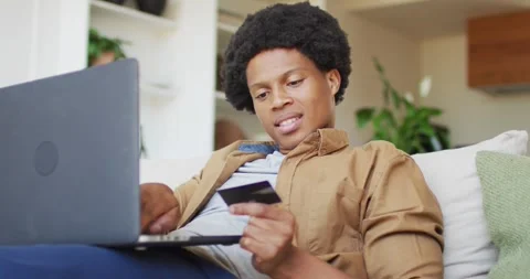 African american man using laptop at home Stock Footage 344643516