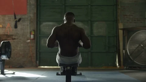 African American man using rowing machine and resting in industrial-style gym 스톡 동영상 124457208