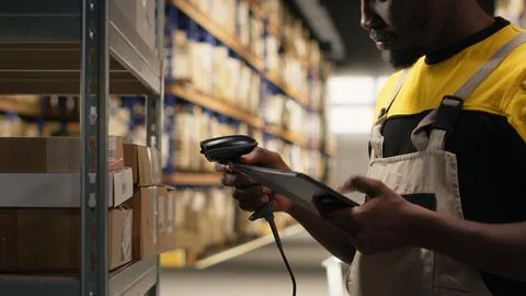 African american man using scanner to register barcodes tags in inventory Stock Photos