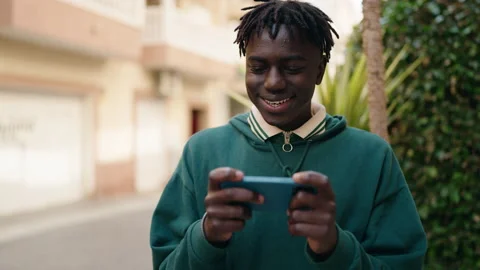 African american man using smartphone with winner expression at street Stock Footage 171788754