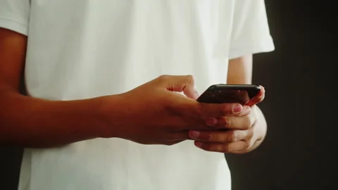African American man using smartphone. Young guy texting at phone, teenager Stock Footage 231428041
