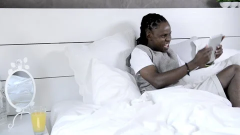African american man using tablet computer in luxury bedroom Stock Footage 199629428