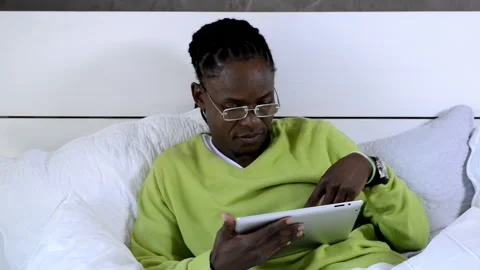 African american man using tablet computer in luxury bedroom Stockbeeldmateriaal 199629466