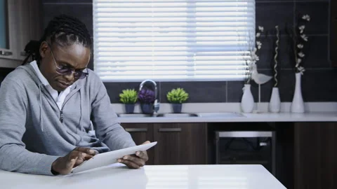African american man using tablet computer in modern kitchen Stock Footage 199630094