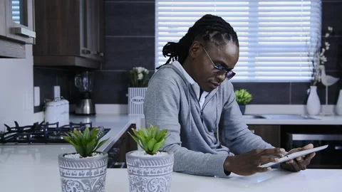 African american man using tablet computer in modern kitchen 스톡 동영상 199630098