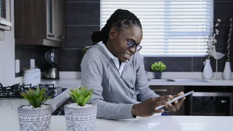 African american man using tablet computer in modern kitchen Vidéo 199630103