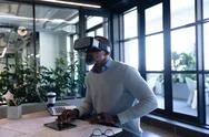 African American Man Using Virtual Reality In Office Stock Photos