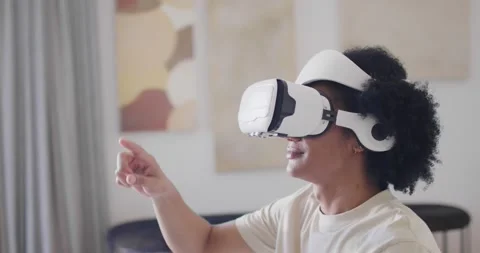 African American man in white VR headset at home, reaching right index finger Stock Footage 337239094