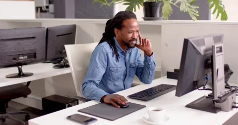 African American man working on computer in office, smiling and enjoying work Stock Footage 345652830