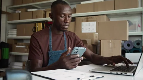 African American Manager Using Smartphone when Filling Parcel Data at Storehouse Stock Footage 281717676