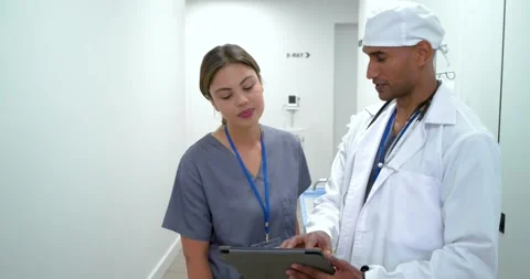 African American medical team using tablet in corridor checking CT as aid Stock Footage 339558656