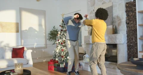 African American men dancing, celebrating holiday by Christmas tree in living Stock Footage 344656556