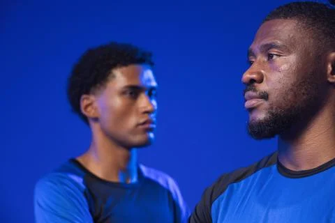 African American men posing in studio against blue backdrop, showing blue and Stock Photos