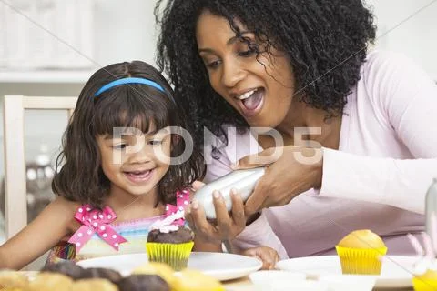African american mother mixed race daughter frosting icing cakes Stock Photos