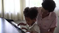 African American Mother Playing Piano With Daughter In Home . Black Mom With Stock Footage