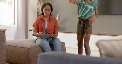 African American mother tapping tablet as daughter pointing, putting on VR Stock Footage 336957945