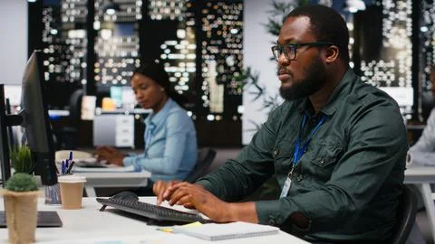 African american office workers solving tasks after hours at workplace Stock Photos
