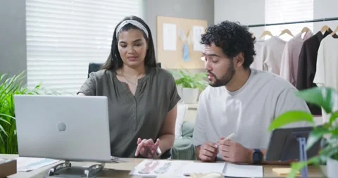 African American partners collaborating after laptop cue, typing and pointing at Stock Footage 344654949