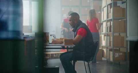 African American post office worker works on laptop computer Stock Footage 307583436