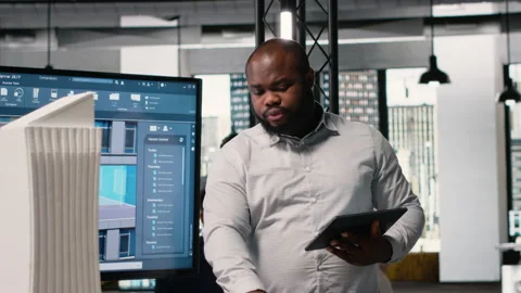 African american real estate developer reviews city planning layout on laptop Stock Footage 316649717